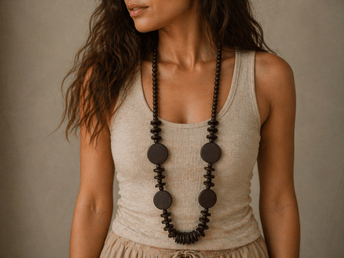 chunky long wood necklace being worn by a model wearing a white top Main image