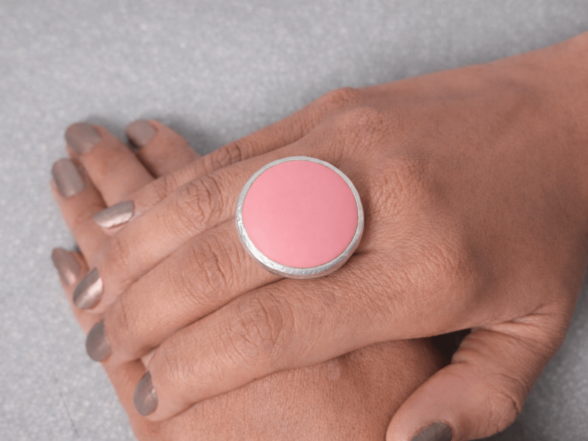 A models hand wearing a round pink ring