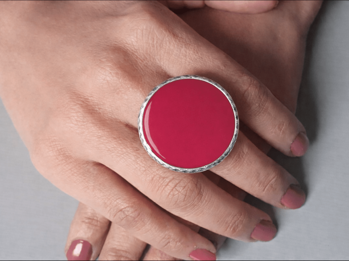 A models hands wearing a large red  ring