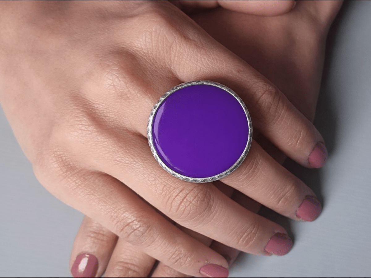 A models hands wearing a large purple ring