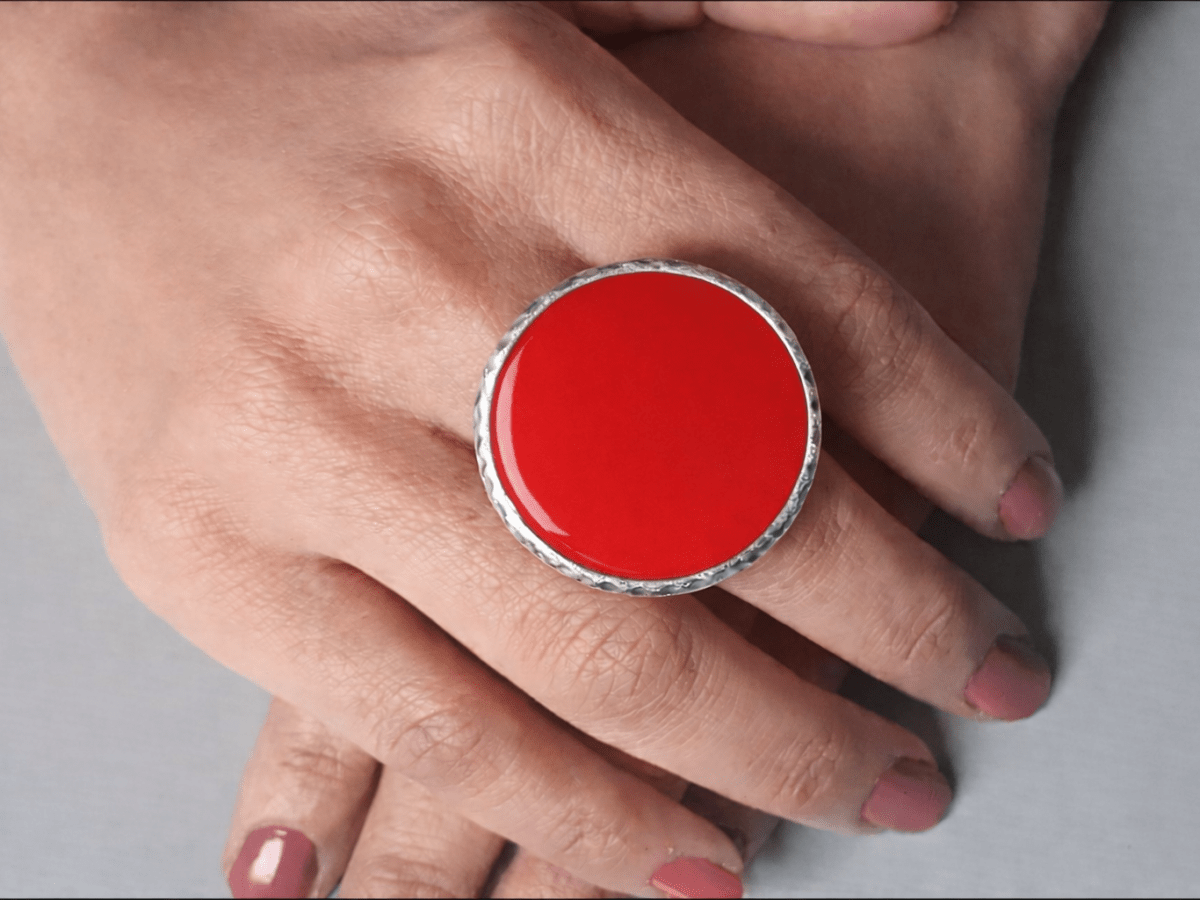 A models hands wearing a large red ring