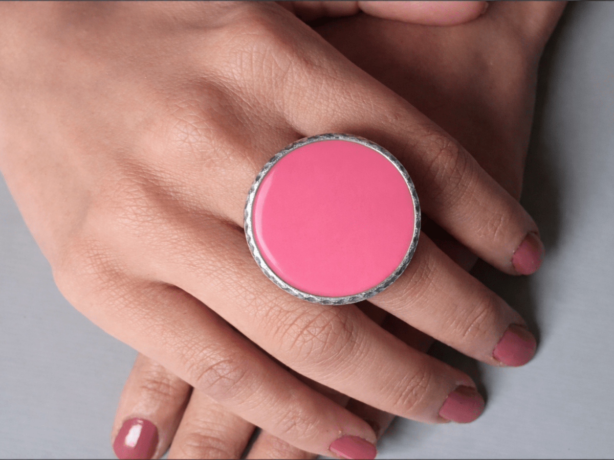 A models hands wearing a large deep pink ring