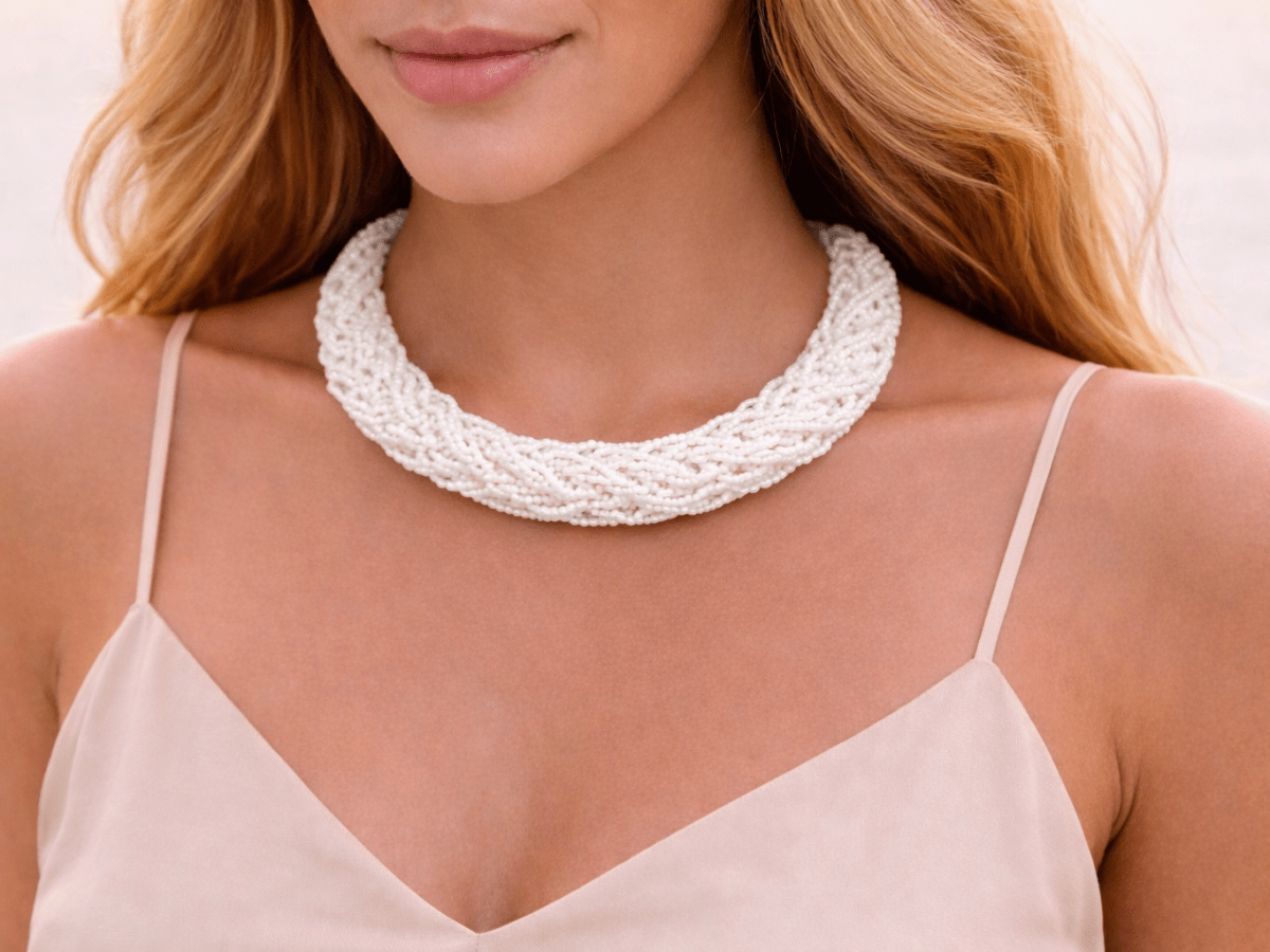 White seed bead rope choker necklace being worn by a model  in a white top