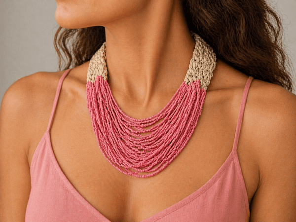 layered pink seed bead necklace being worn by a model in a pink top