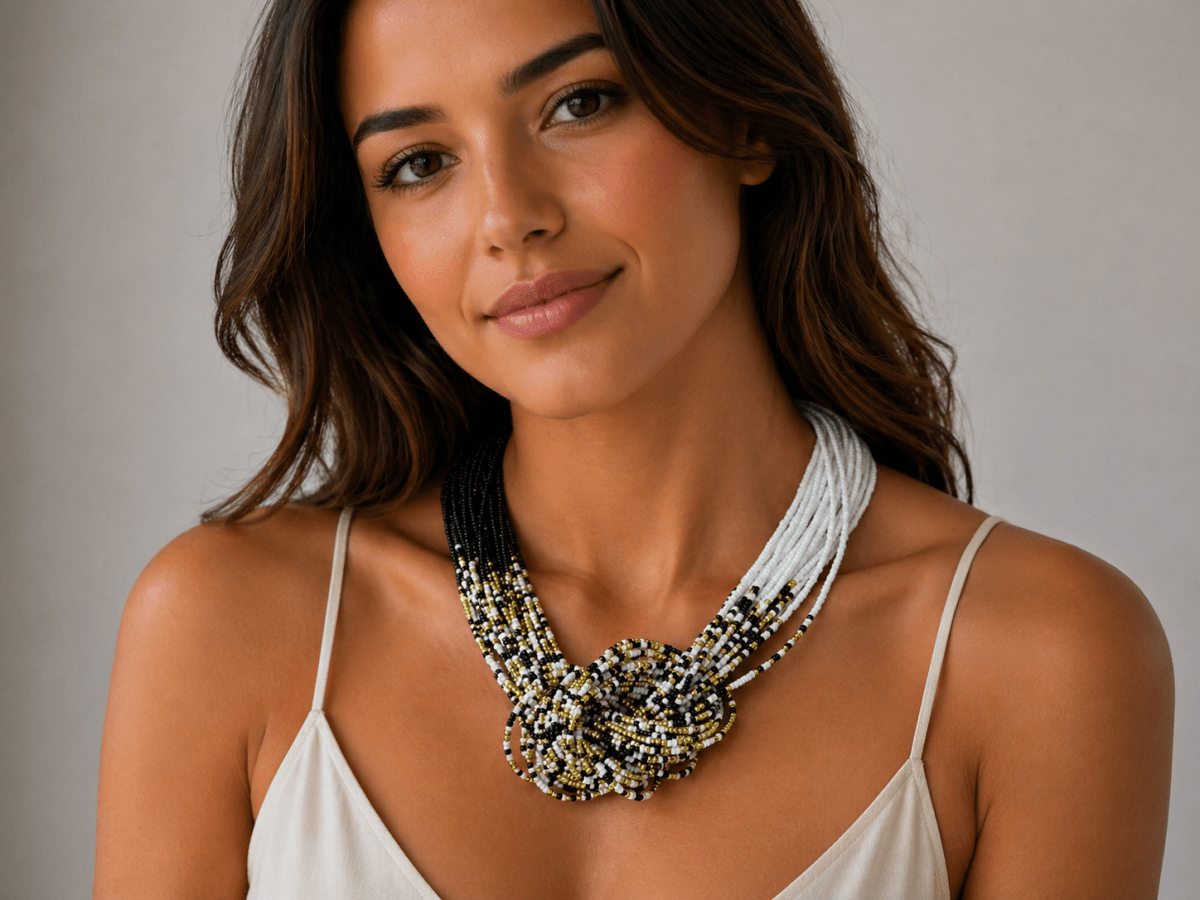 knotted seed bead necklace in black gold and white being worn by a model with a white top Main image