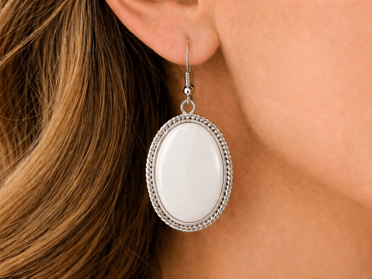 Clean, soft, and effortlessly elegant. These oval drop earrings feature a smooth white jade stone set within a twisted silver-tone frame, creating a light, refined finish - Corky & Stoner