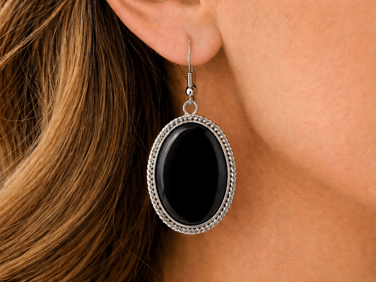 Sleek, bold, and effortlessly refined. These oval drop earrings feature a polished black onyx stone set within a twisted silver-tone frame, creating a strong, minimalist finish  - Corky & Stoner