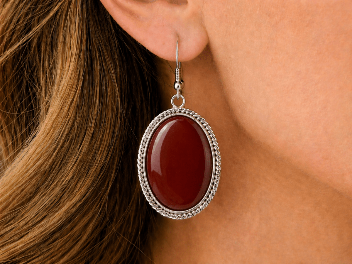 Rich, warm, and full of depth. These oval drop earrings feature a deep red carnelian stone set within a twisted silver-tone frame, creating a bold yet refined finish - Corky & Stoner