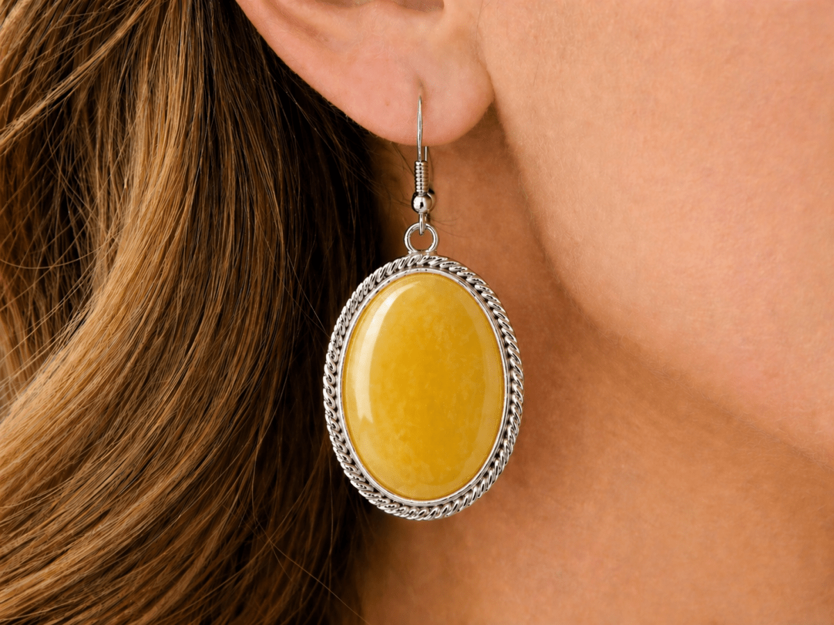  Warm, vibrant, and full of character. These oval drop earrings feature a smooth yellow jade stone set within a twisted silver-tone frame, creating a clean but eye-catching finish - Corky & Stoner