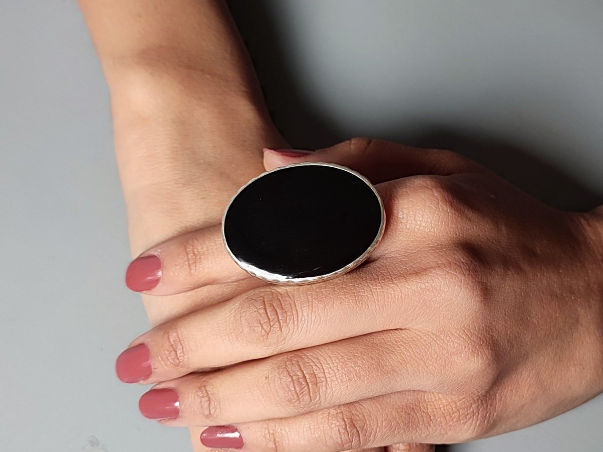 A models hand wearing a black oval ring
