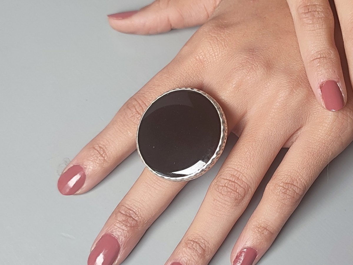 A models hands wearing a large black ring