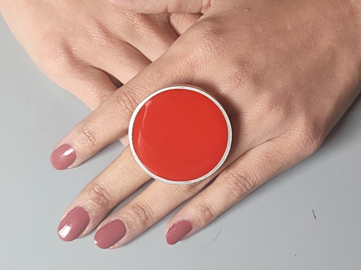 A models hands wearing a large red ring