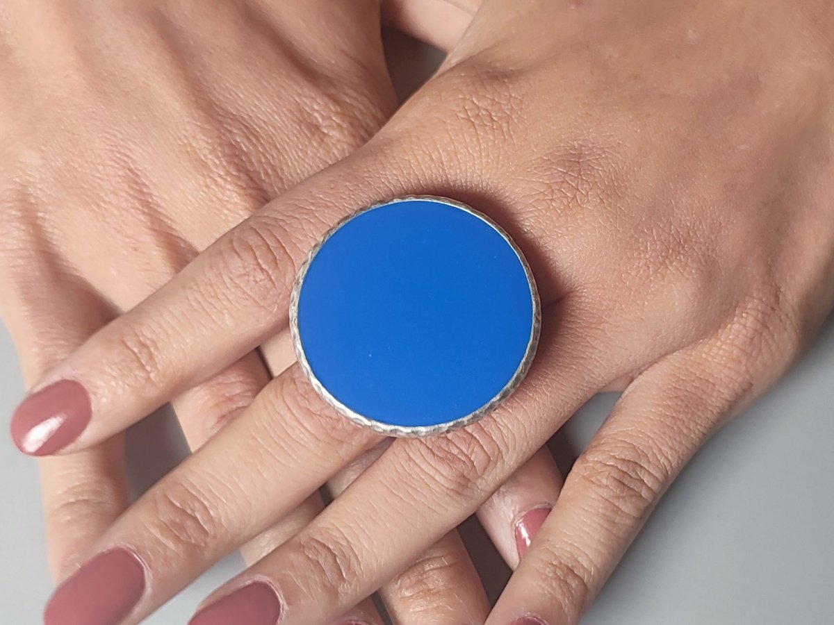 A models hands wearing a large blue ring