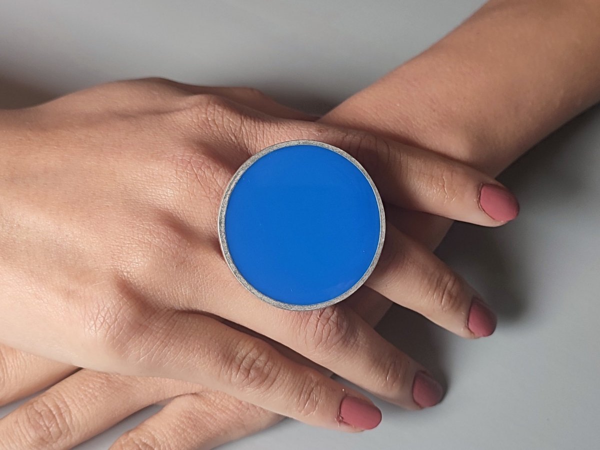 A models hands wearing a blue ring