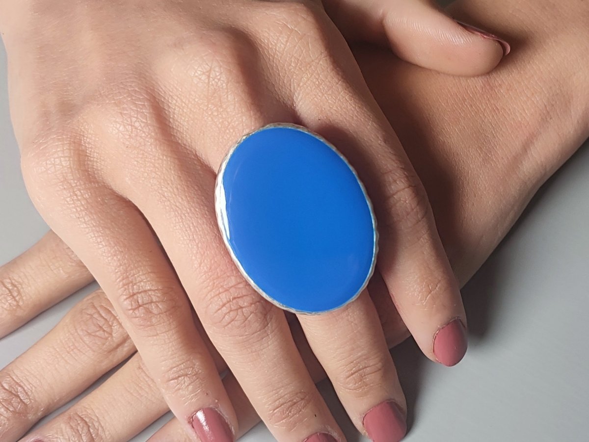 A models hand wearing a blue oval ring
