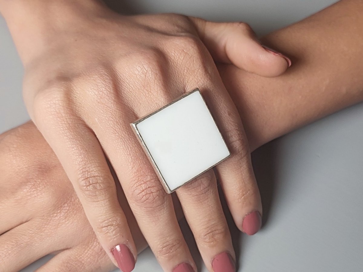 Models hands wearing a square white ring Main image