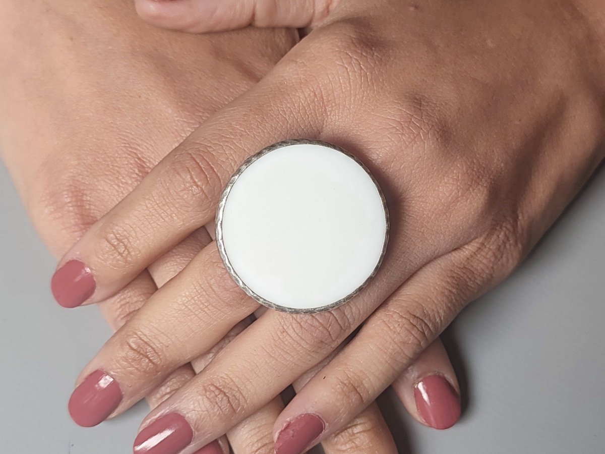 A models hands wearing a large white ring