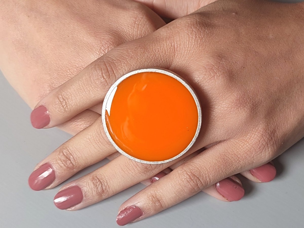 A models hands wearing an orange ring