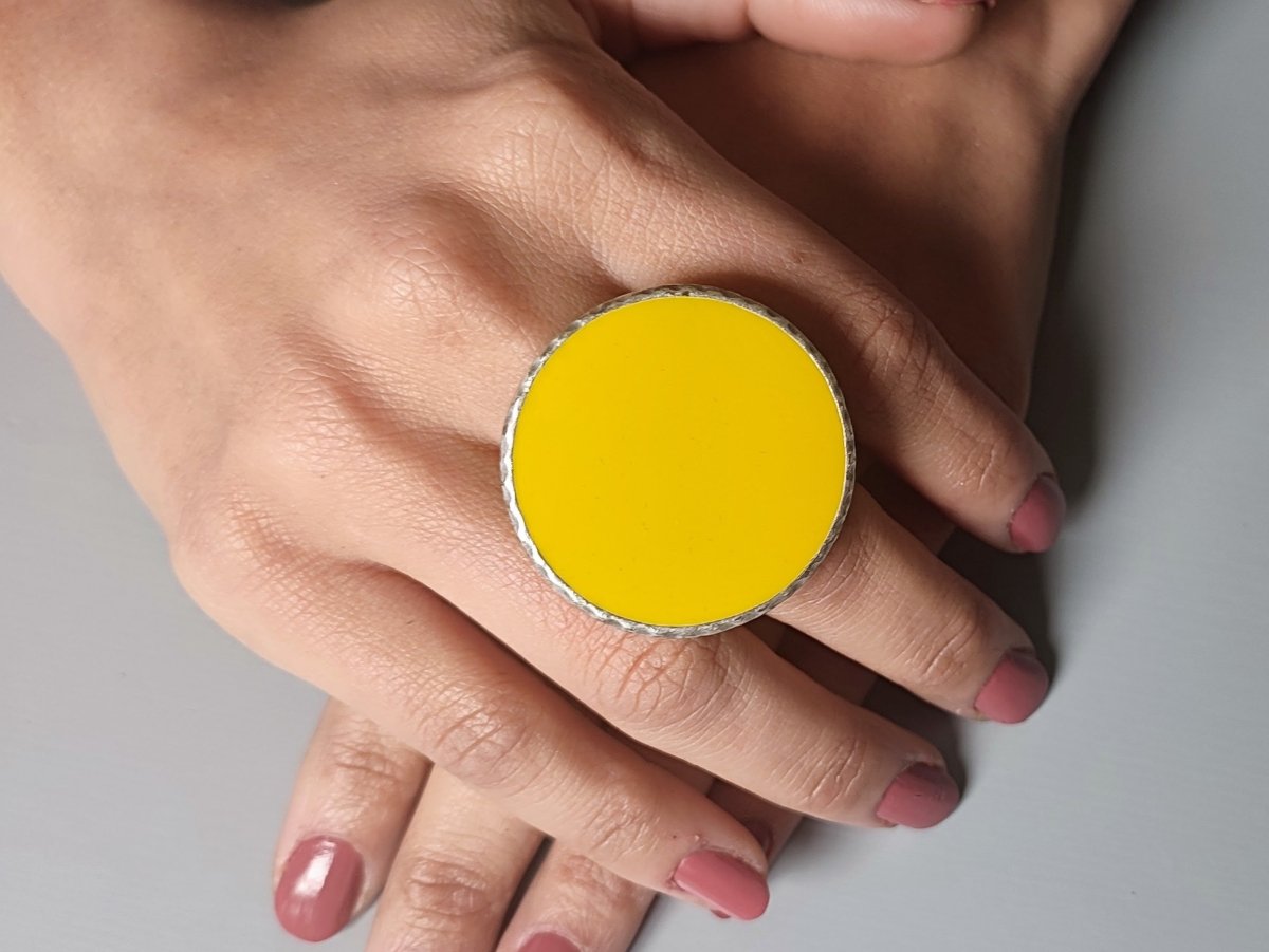 A models hands wearing a large yellow ring