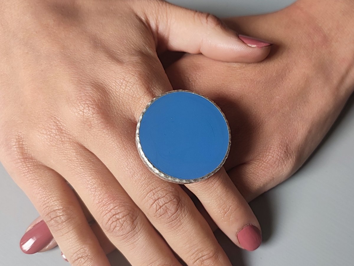 A models hands wearing a large blue ring Main image