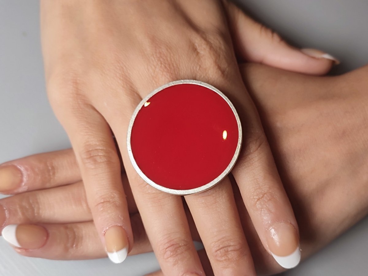 A models hands wearing a large red ring