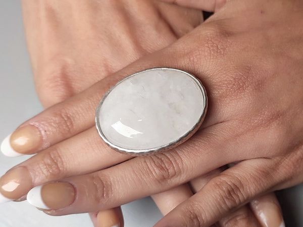a white crystal statement ring worn on a models hand