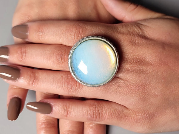 a round opalite silver ring worn on a models hand