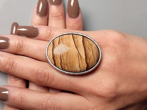 a large picture jasper ring worn on a models hand