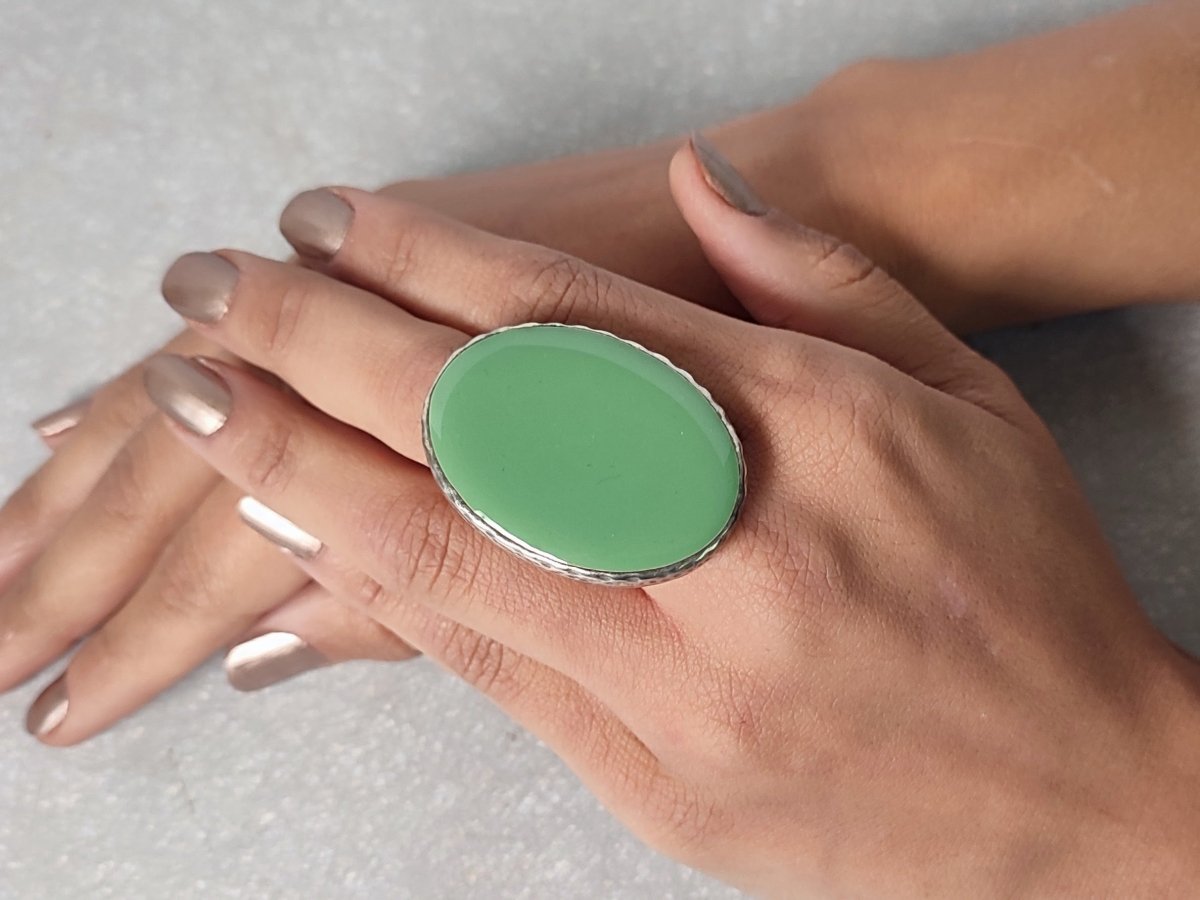 A models hand wearing a sage green oval ring Main image