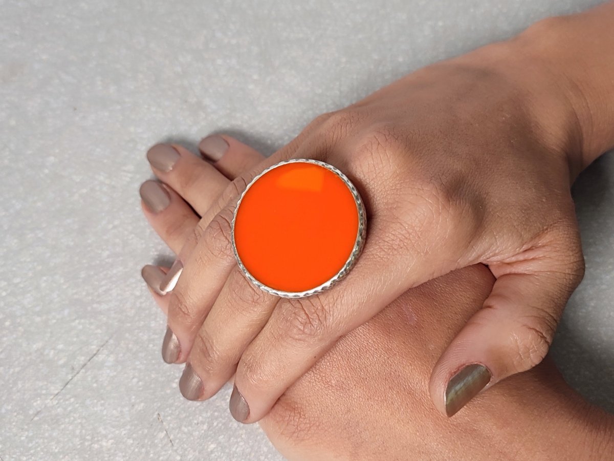 A models hands wearing a large orange ring