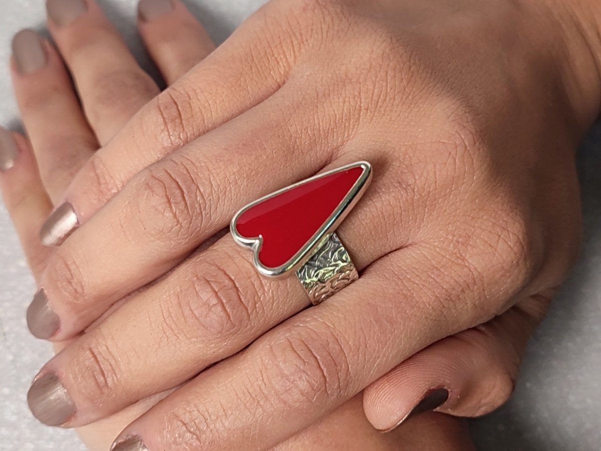 A models hands wearing a red heart ring