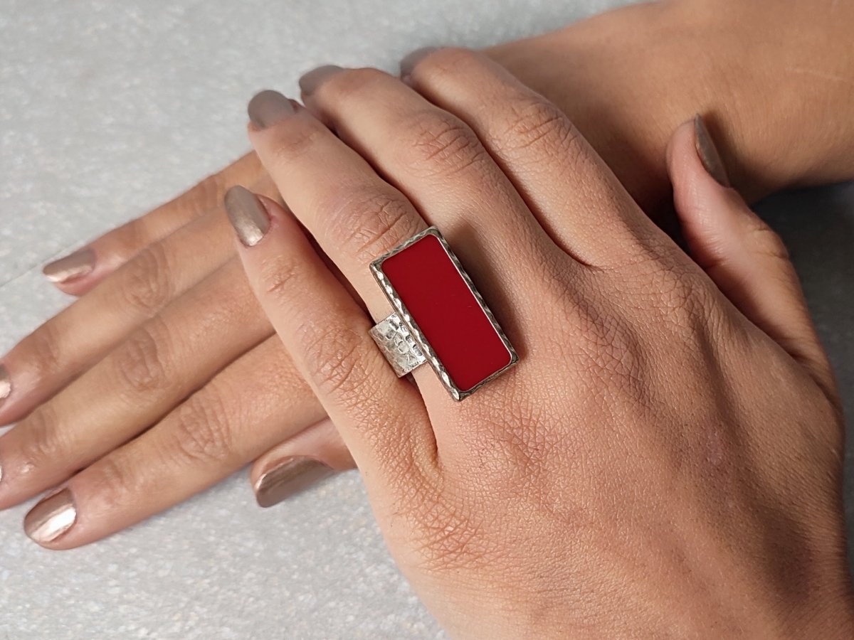 A models hand wearing a rectangular dark red ring Main image
