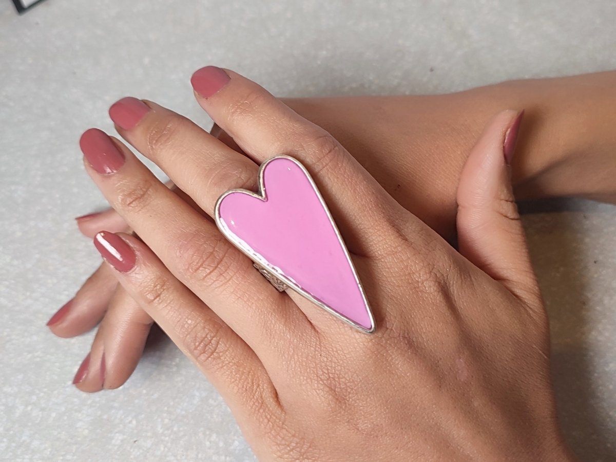 A models hand wearing a large pale pink heart shaped ring