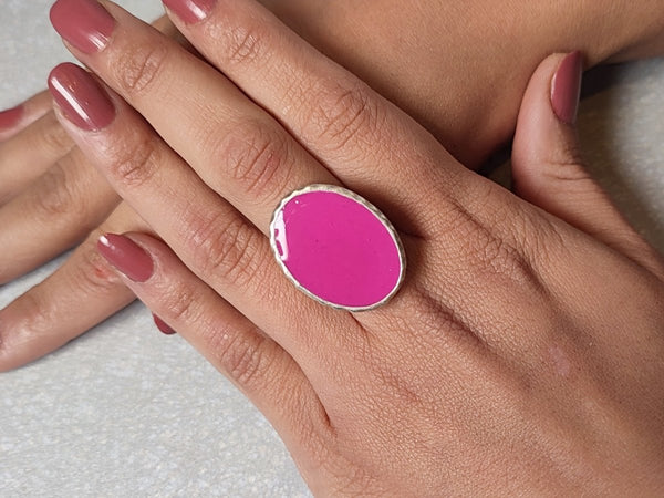 A models hands wearing a bright pink ring