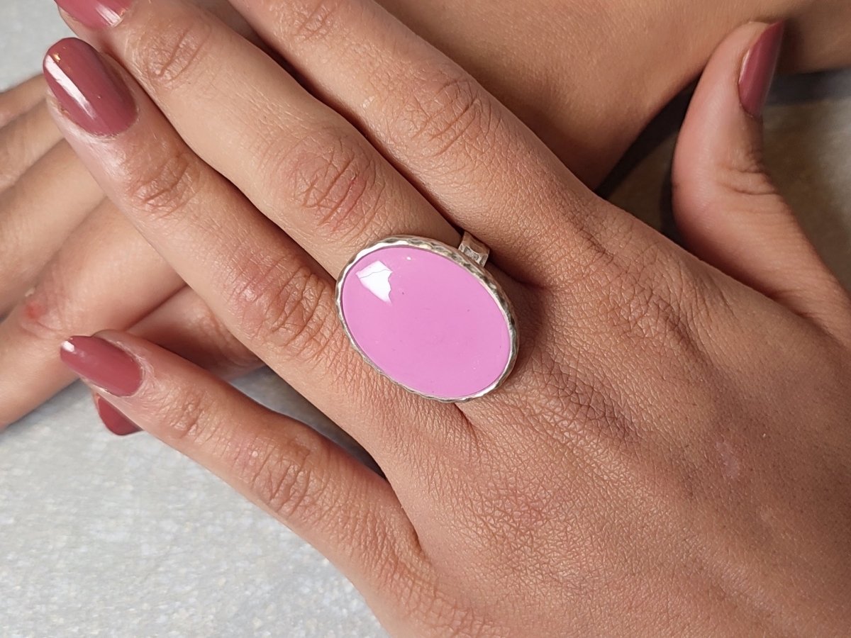 A models hands wearing a pale pink ring