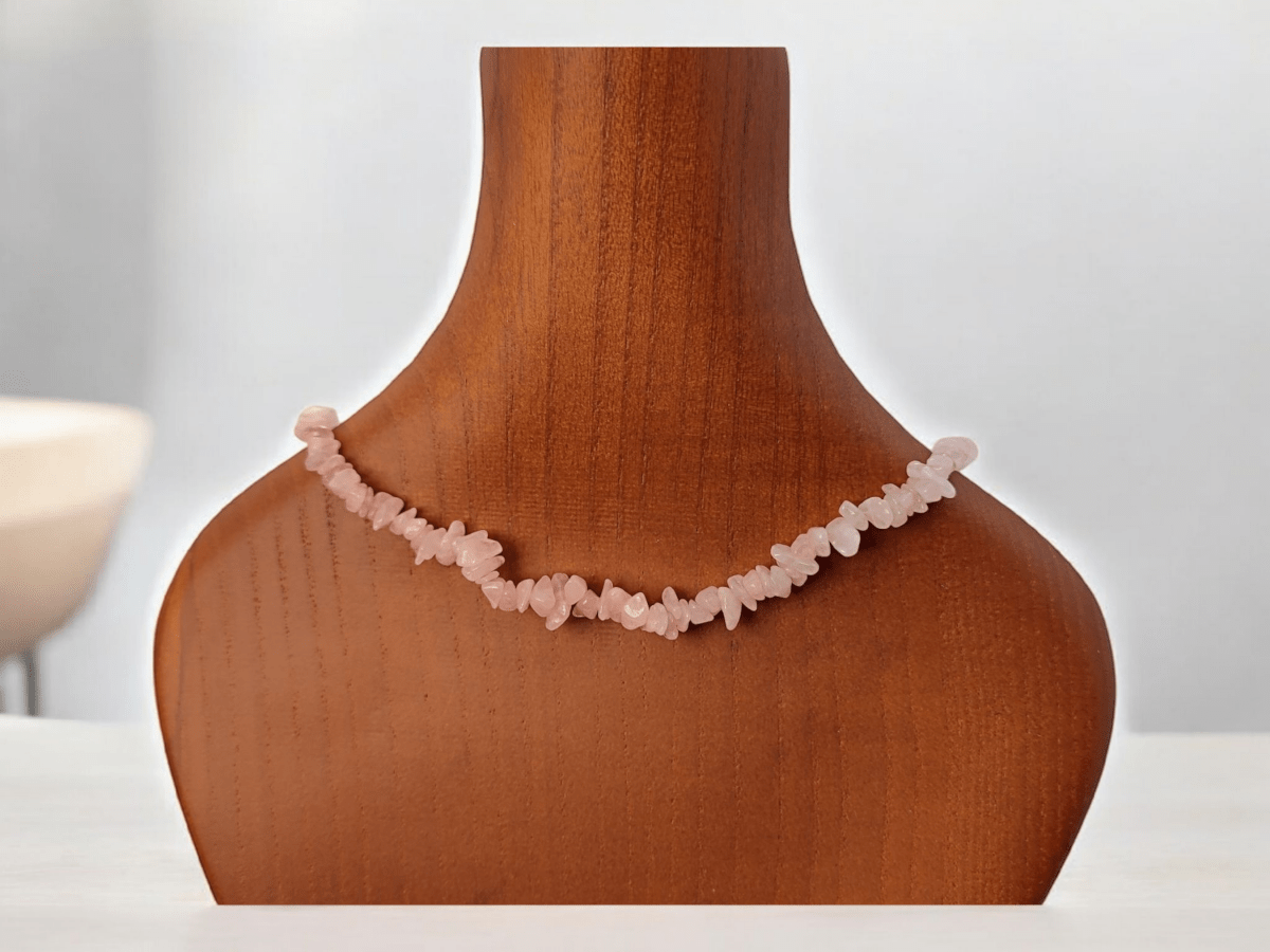 A Rose Quartz beaded choker on a wooden bust