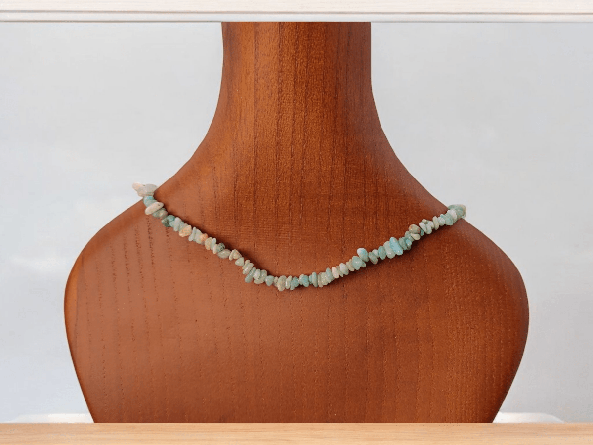 An Amazonite beaded choker on a wooden bust