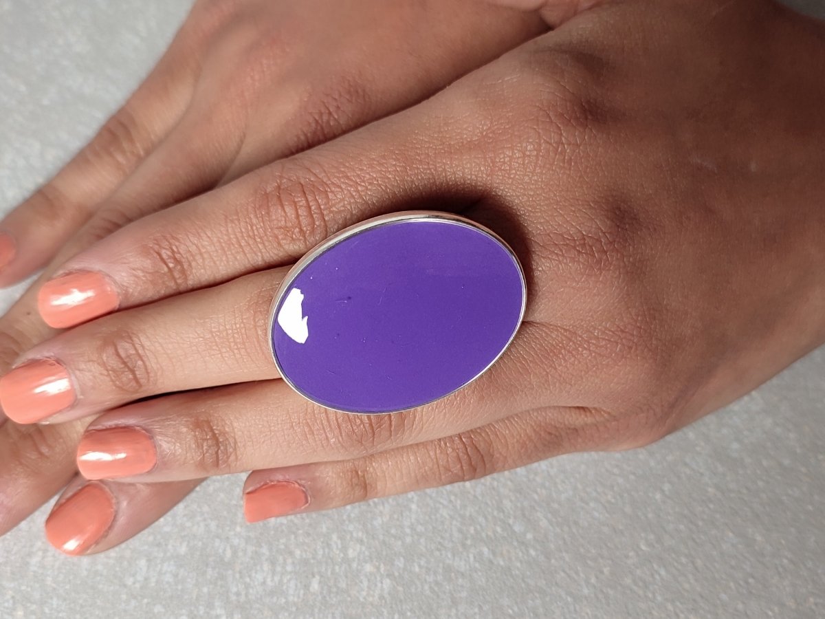 A models hands wearing a large purple oval ring Main image