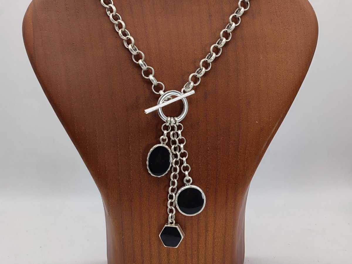 Harmony Black Charm  Necklace with 3 black charms, on a wooden bust