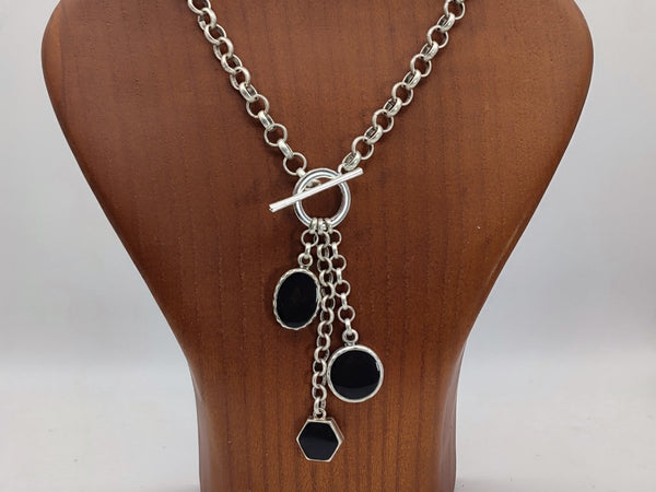 Harmony Black Charm  Necklace with 3 black charms, on a wooden bust