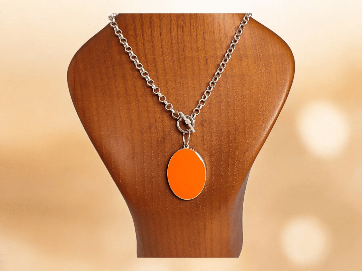 An orange pendant on a wooden bust Main image