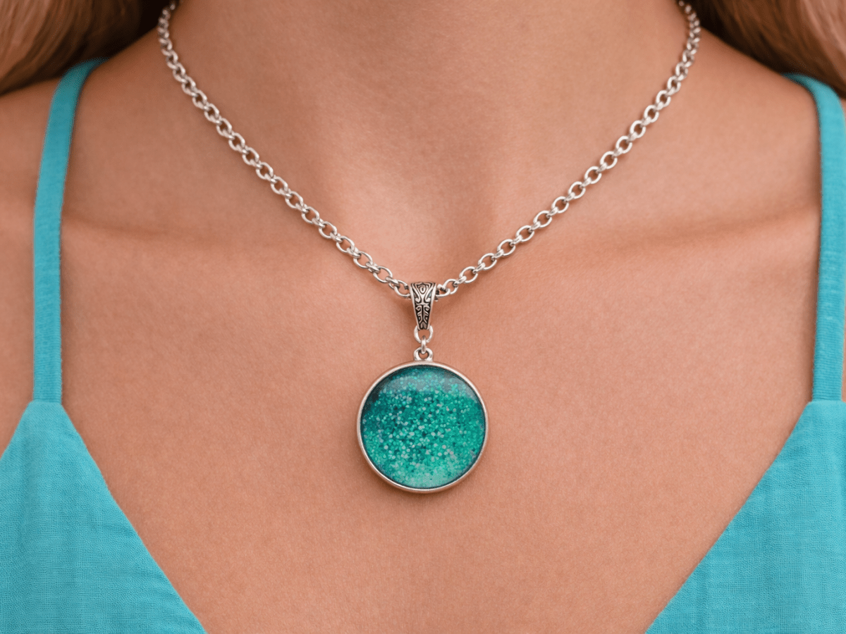 turquoise glass pendant being worn by a model in a turquoise top Main image