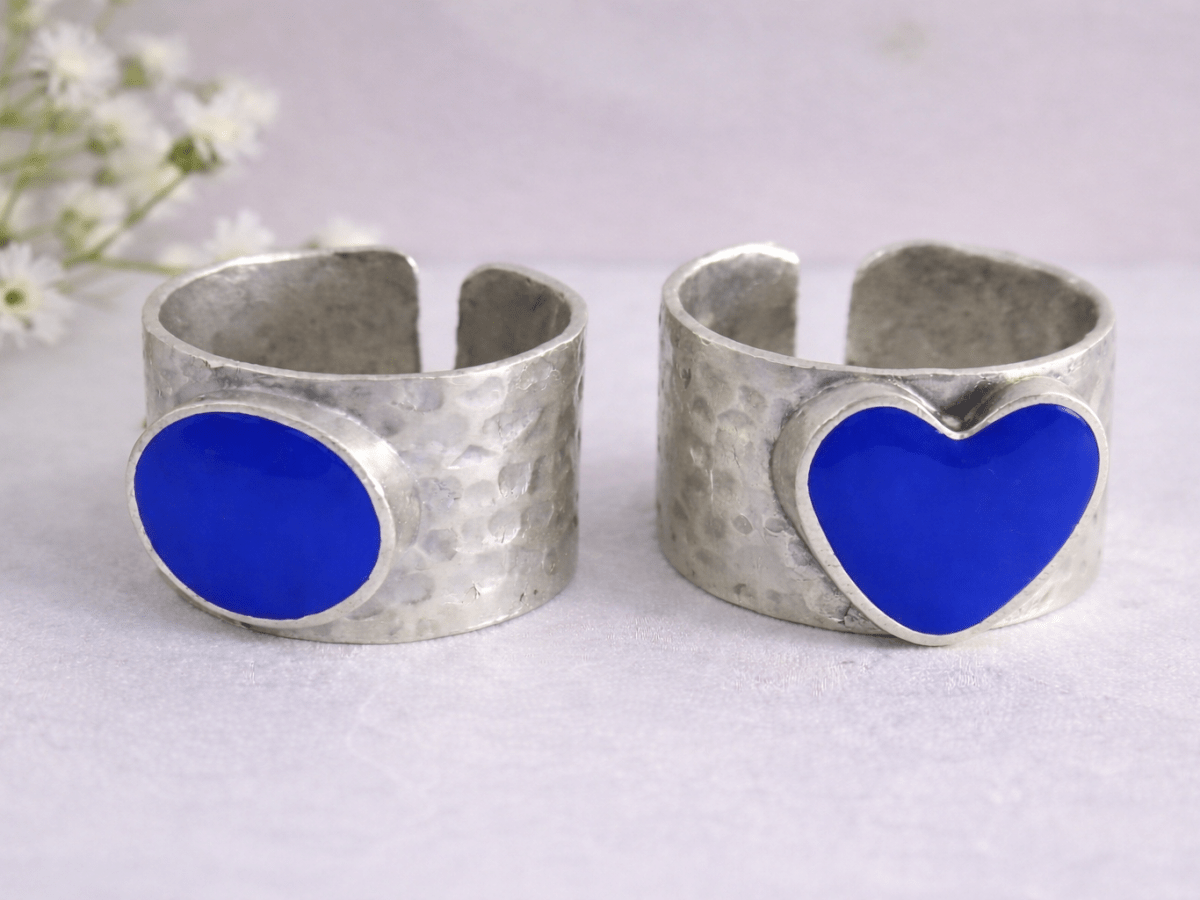 A picture of 2 bands rings, one with a bright blue heart one with a bright blue circle