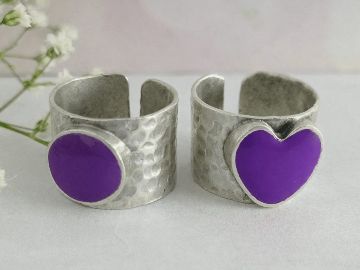 A picture of 2 bands rings, one with a purple heart one with a purple circle