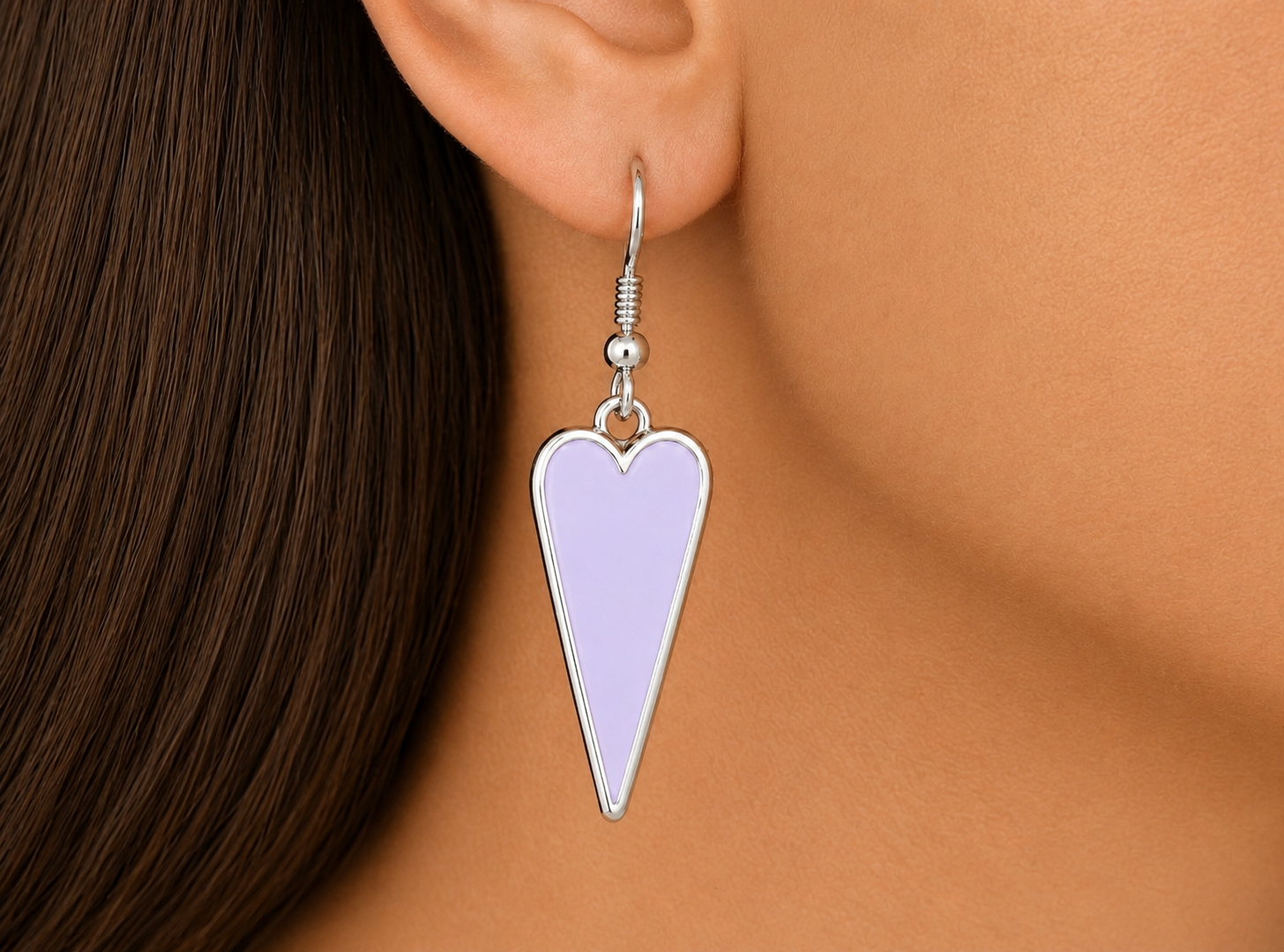 Heart-shaped earring worn by a person with brown hair on a beige background Main image