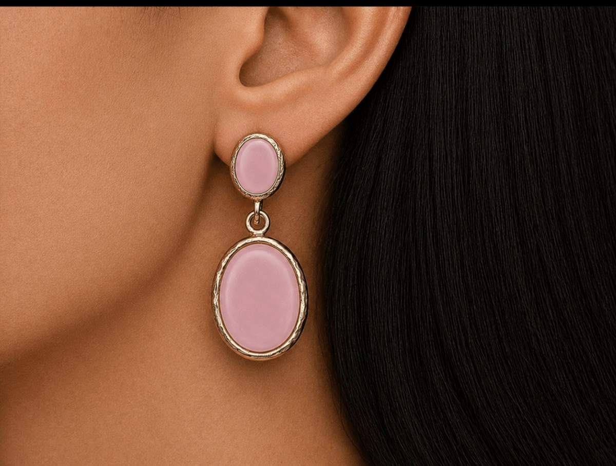 A model wearing some oval pink dangle drop earrings
