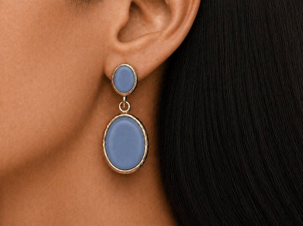 A model wearing some oval blue dangle drop earrings