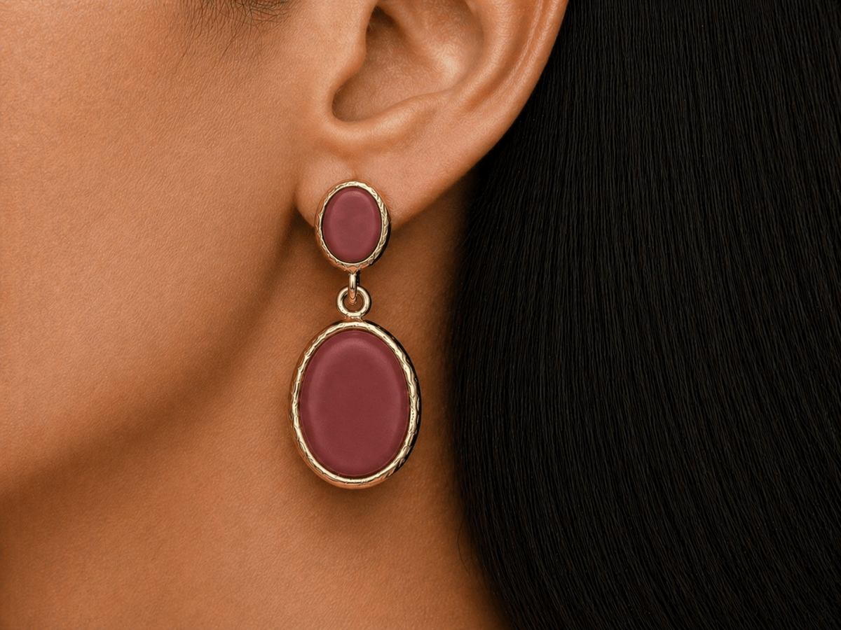 A model wearing some oval dark red dangle drop earrings
