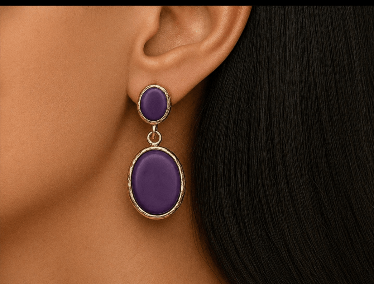 A model wearing some oval purple dangle drop earrings