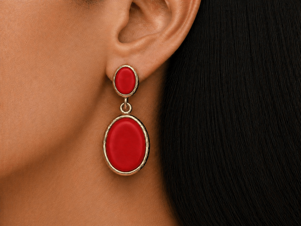 A model wearing some oval red dangle drop earrings